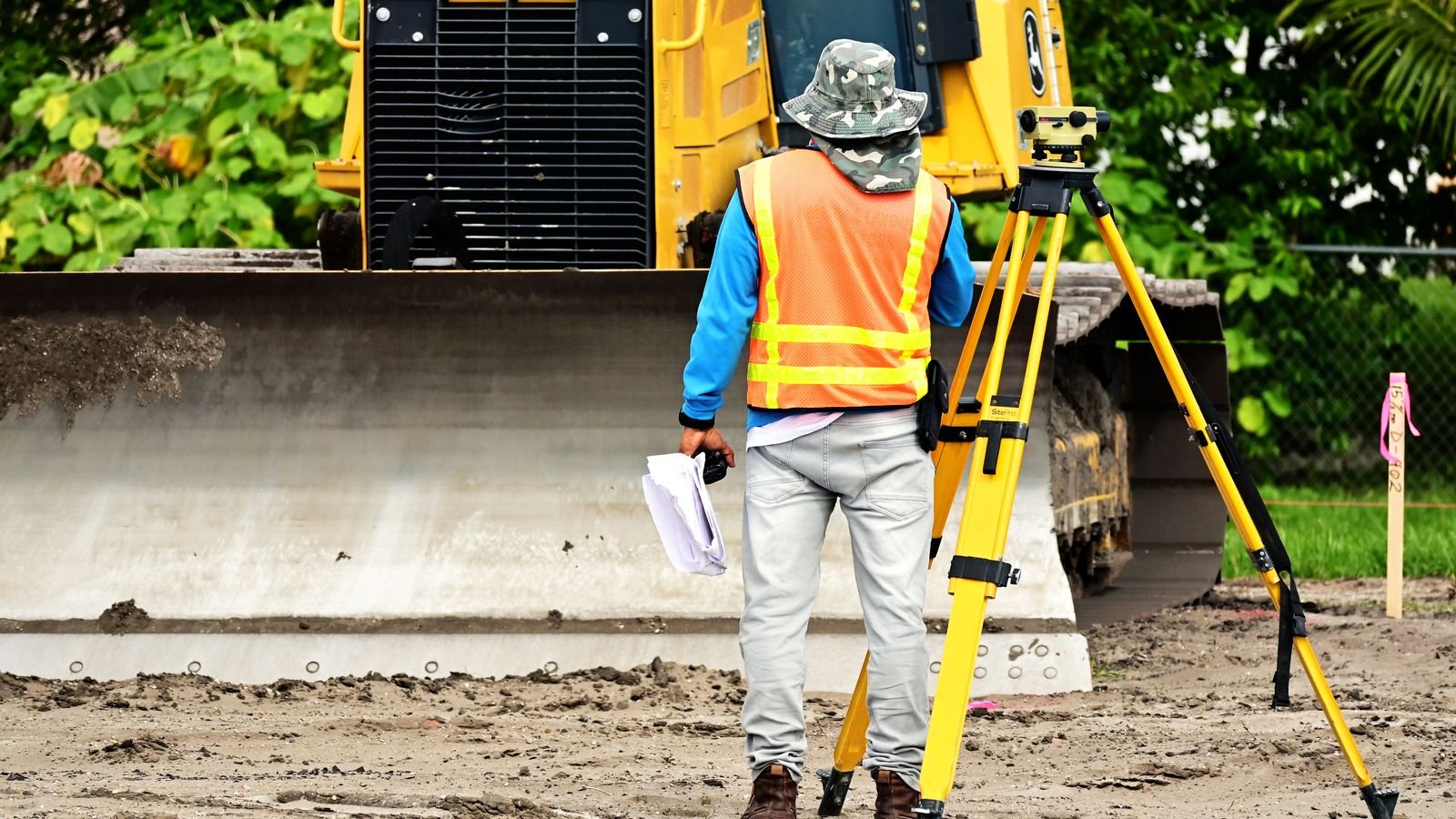 Géomètre-expert avec équipement de mesure sur un chantier