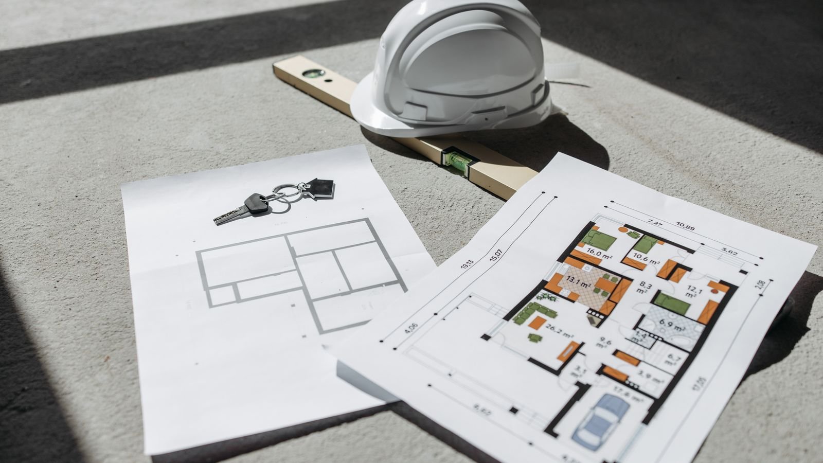 Plans architecturaux avec casque et clés de maison neuve