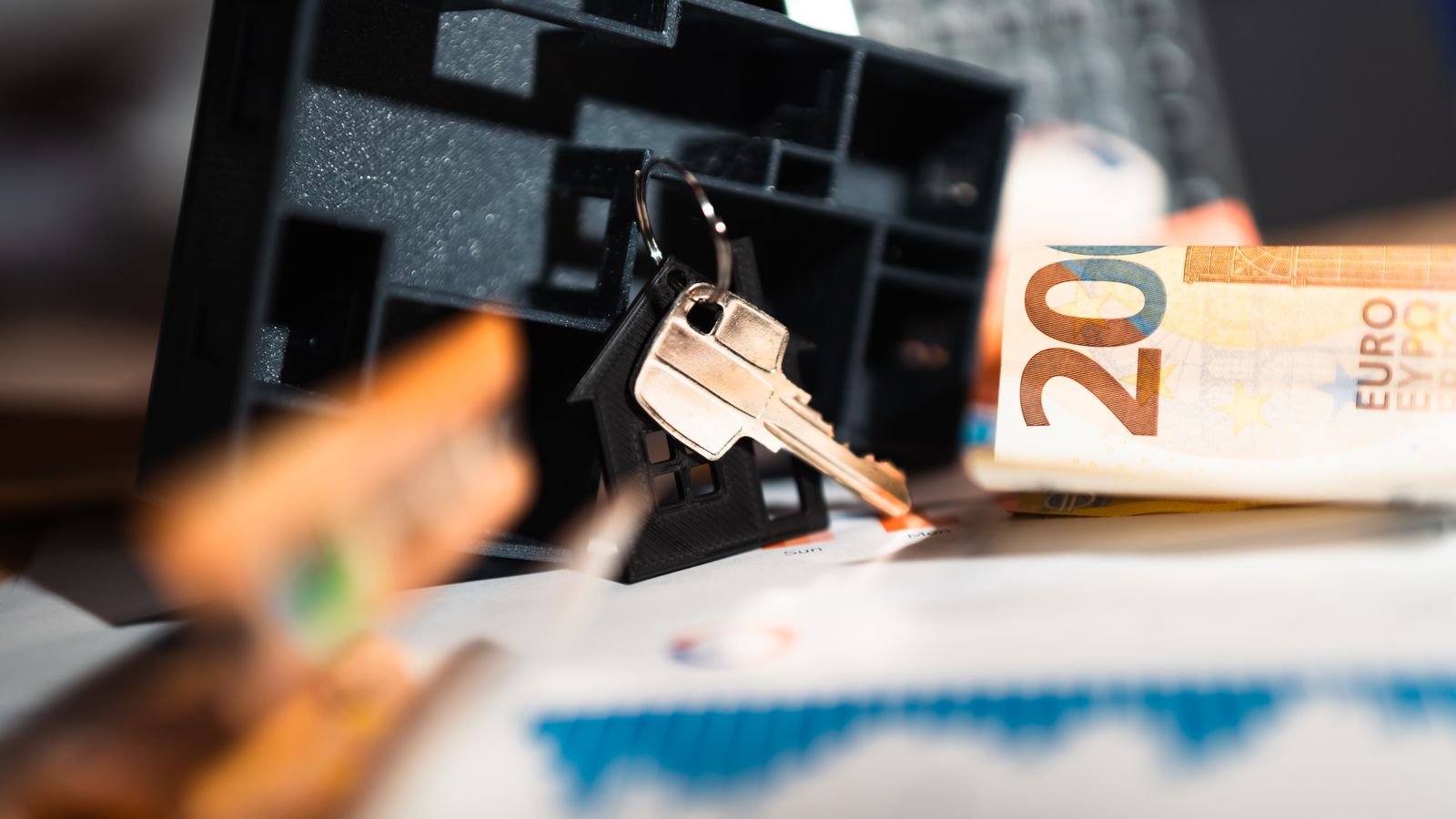 Clés de maison posées sur des billets d euros et des graphiques d investissement
