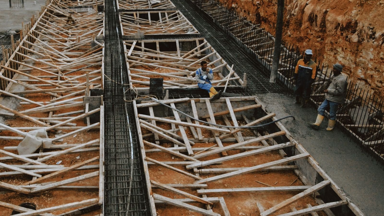 Chantier de fondations avec ossature bois en cours de coulage